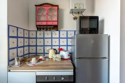 a kitchen with a refrigerator and a pink cabinet at Center Suite Garbatella in Rome