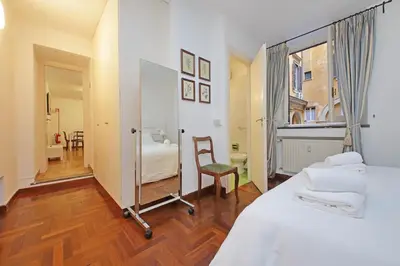 a bedroom with a bed and a chair and a window at Pantheon Apartment Rondanini in Rome