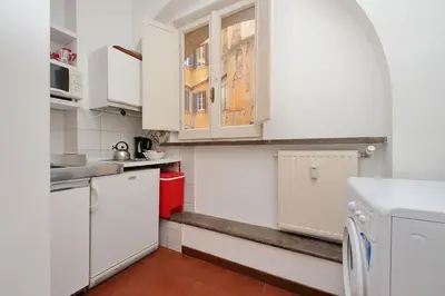 a kitchen with white cabinets and a washer and dryer at Pantheon Apartment Rondanini in Rome