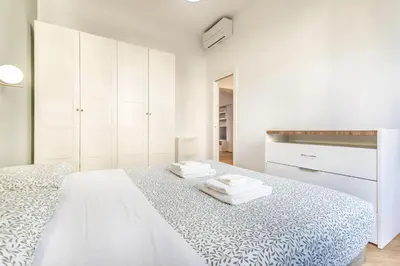 a white bedroom with white cabinets and a bed at SanGiò - Appartamento San Giovanni in Rome