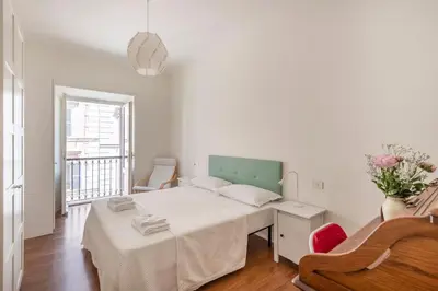 a white bedroom with a bed and a piano at Trastevere Penthouse in Rome