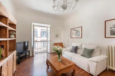 a living room with a white couch and a table at Trastevere Penthouse in Rome