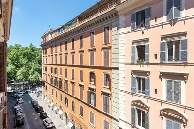 a tall building with cars parked on a street at Trastevere Penthouse in Rome