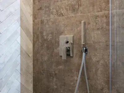 a shower stall with a soap dispenser on a wall at BNB Ostiense in Rome