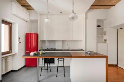 a kitchen with white cabinets and a red refrigerator at Hip Pad in Garbatella in Rome