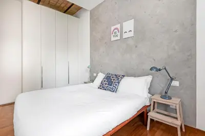 a bedroom with a bed and a lamp on a table at Hip Pad in Garbatella in Rome