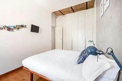 a bedroom with a white bed with a lamp on it at Hip Pad in Garbatella in Rome