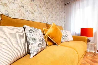 a yellow couch with pillows on it in a living room at ZENO 13 Paradiso - Casa Verde in Rome