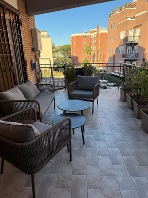 a patio with furniture and tables on a balcony at Appartamento in Rome