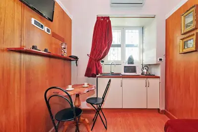 a kitchen with a table and chairs in a room at Colosseum Studio in Rome