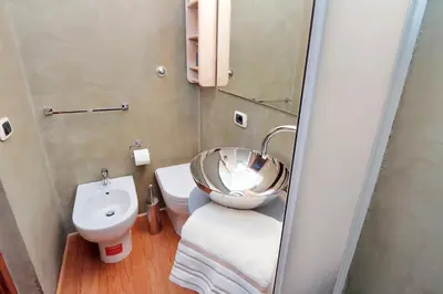 a bathroom with a bowl sink and a toilet at Colosseum Studio in Rome