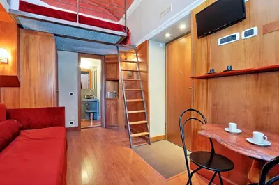 a living room with a red couch and a table at Colosseum Studio in Rome