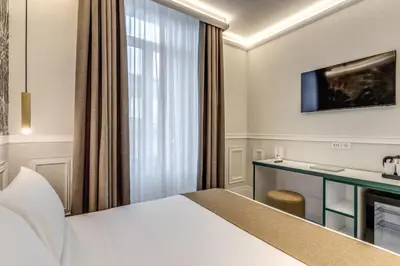 a hotel room with a bed and a desk at Relais Marco Polo in Rome