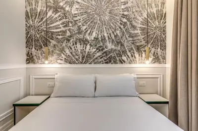 a bedroom with a bed and a painting on the wall at Relais Marco Polo in Rome