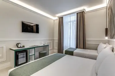a hotel room with two beds and a television at Relais Marco Polo in Rome
