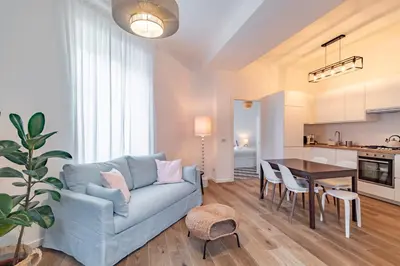 a living room with a blue couch and a table at Domus Ana- Modern Elegance, steps away from the colosseum and the historic center in Rome