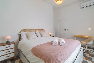 a bedroom with a bed with two towels on it at Domus Ana- Modern Elegance, steps away from the colosseum and the historic center in Rome