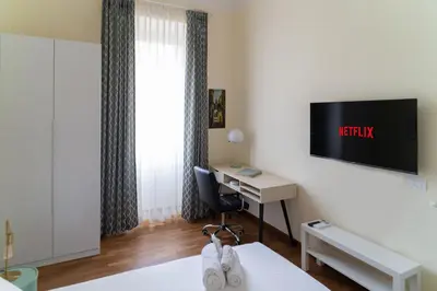 a hotel room with a desk and a tv on the wall at Ampio appartamento A 500 mt dai musei Vaticani in Rome