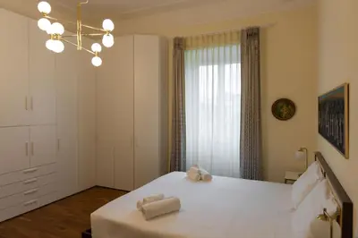 a bedroom with a large white bed with a chandelier at Ampio appartamento A 500 mt dai musei Vaticani in Rome
