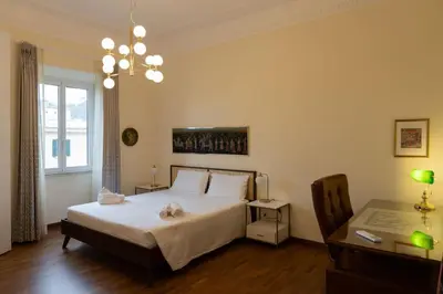 a bedroom with a bed and a desk and a window at Ampio appartamento A 500 mt dai musei Vaticani in Rome