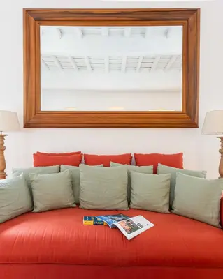 a red couch with pillows and a mirror at Luxury House Lungaretta - ZENO 50 in Rome