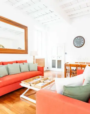 a living room with a red couch and a table at Luxury House Lungaretta - ZENO 50 in Rome
