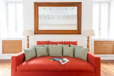 a red couch in a living room with a mirror at Luxury House Lungaretta - ZENO 50 in Rome