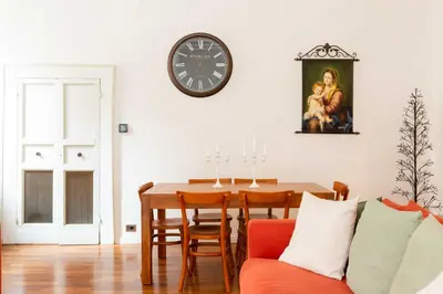 a dining room with a table and a clock on the wall at Luxury House Lungaretta - ZENO 50 in Rome