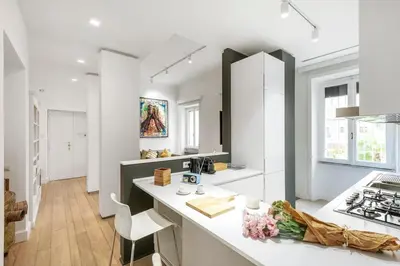 a white kitchen with a counter and a sink at Bordeaux luxury apartment Rome in Rome