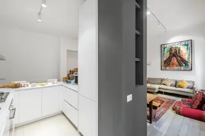 a kitchen with white cabinets and a living room at Bordeaux luxury apartment Rome in Rome