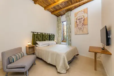 a bedroom with a bed and a chair and a television at New home trastevere in Rome