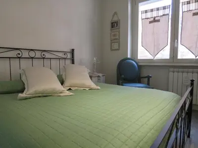 a green bed with two pillows and a chair in a bedroom at Casa Francesca in Rome