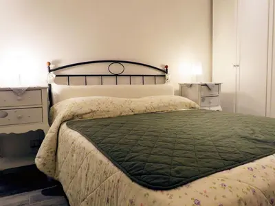 a bedroom with a large bed with a green comforter at Casa Francesca in Rome