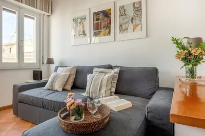 a living room with a gray couch and a table at Menta luxury apartment Rome in Rome