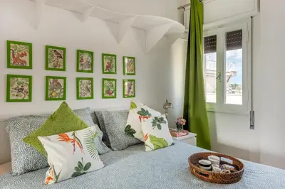 a living room with a bed and a green curtain at Menta luxury apartment Rome in Rome