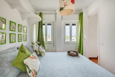 a bedroom with a large bed with green curtains at Menta luxury apartment Rome in Rome