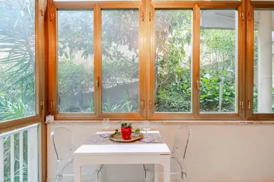 a table and chairs in a room with windows at Welcome to Retreat in Trastevere in Rome