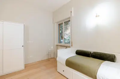 a white bedroom with a bed and a window at Welcome to Retreat in Trastevere in Rome