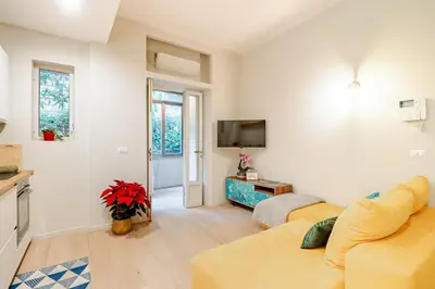 a living room with a yellow couch and a tv at Welcome to Retreat in Trastevere in Rome