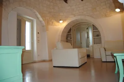 a living room with white furniture and an archway at Trullo Amato with exclusive pool in Rome