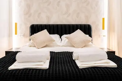 a bed with white sheets and pillows on it at Centocinque Aparthouse - Luxe in Rome