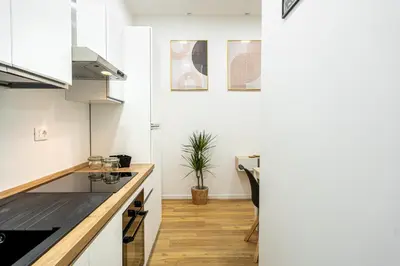 a kitchen with white cabinets and a counter top at Centocinque Aparthouse - Luxe in Rome