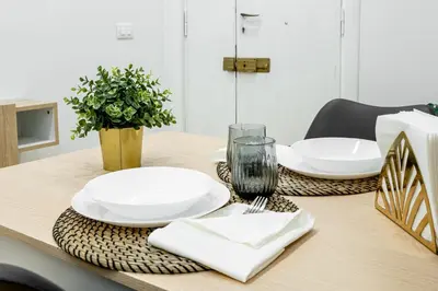 a table with white plates and napkins on it at Centocinque Aparthouse - Luxe in Rome