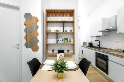 a kitchen and dining room with a wooden table and chairs at Centocinque Aparthouse - Luxe in Rome