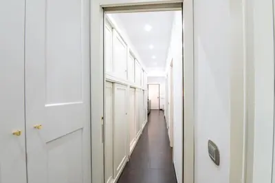 a hallway with white walls and a long hallway with white doors at Butterfly House Ponte Milvio in Rome