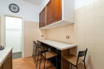 a kitchen with a counter with chairs and a clock at Butterfly House Ponte Milvio in Rome