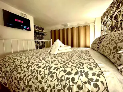 a bedroom with a large bed with a tv on the wall at Machiavelli House in Rome
