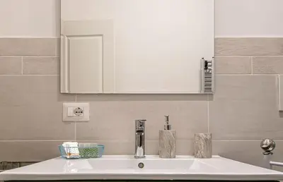 a bathroom sink with a white cabinet above it at Rhome311 - Vatican Apartment in Rome