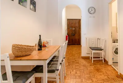 a dining room with a table and chairs and a clock at Rhome311 - Vatican Apartment in Rome