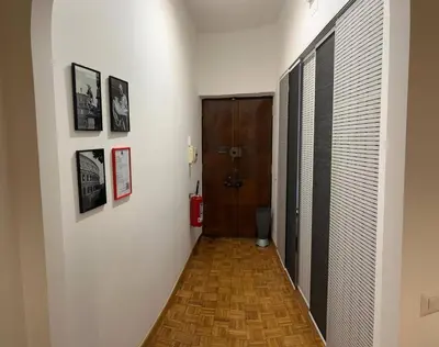 a hallway with a door and some pictures on the wall at Rhome311 - Vatican Apartment in Rome